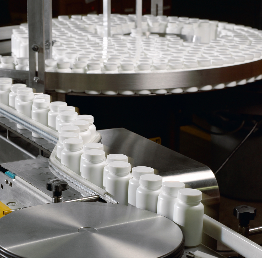 image of Pill bottles going through the pill counter and labeling machinery